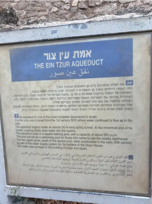 שלט מידע מבולבל שכותרתו אמת עין צור, המוצג בעברית, אנגלית וערבית, מפרט את המשמעות ההיסטורית של מנהרת אביב עתיקה זו. מושלם למטיילים בישראל, האתר מציע הצצה אל ההיסטוריה לאלו המטיילים בטיולים בצפון הארץ.