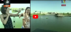 שתי נשים עומדות על מרפסת ליד אגם, מחייכות ומחוות על מקומות מומלצים לטיול. הסצנה מתפצלת עם עוד נוף לאגם מימין, המציג מבנים ומזח. כפתור הפעלה אדום מרוכז, עם טקסט בתסריט שאינו אנגלי מופיע על התמונה.