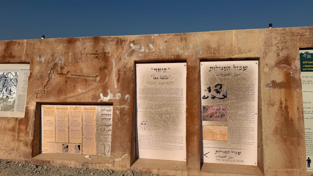 תצוגה על קיר אבן תחת שמיים כחולים וצלולים כוללת מספר לוחות מידע בעברית ובאנגלית אודות THE YATIR ו-THE SCULPTURE TRAIL, יחד עם איורים ארכיאולוגיים ומפות של האתר.